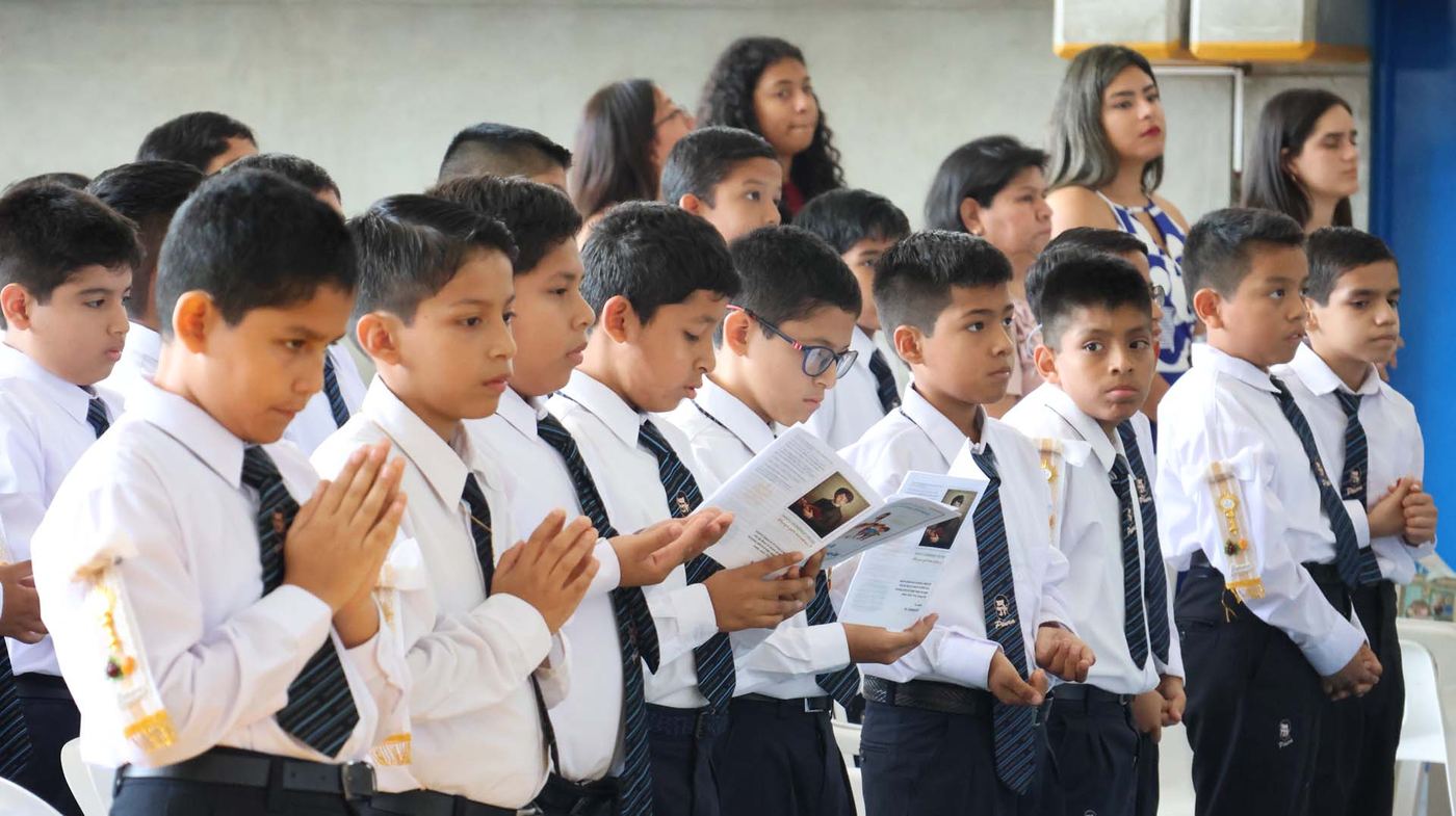 Estudiantes rezando en el aula